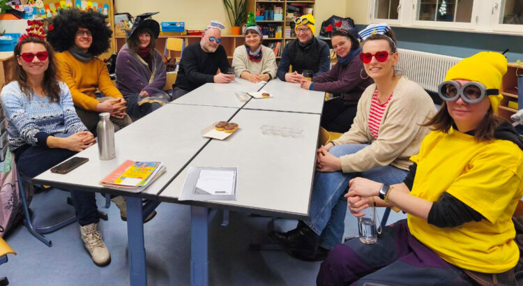 Mitglieder des Fördervereins sitzen verkleidet um einen Tisch